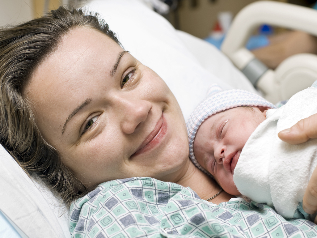 Mother smiling with newborn