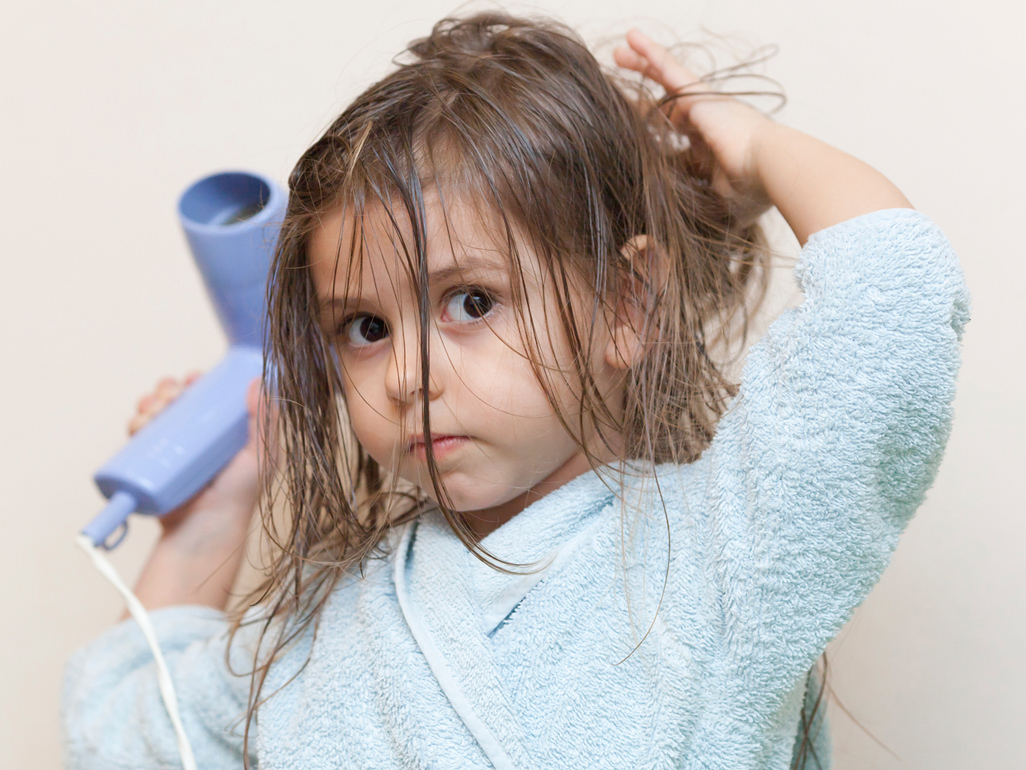 A little girl drying her hair
