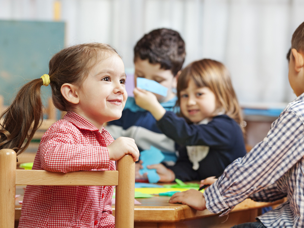 Children sat at a table doing arts and crafts 