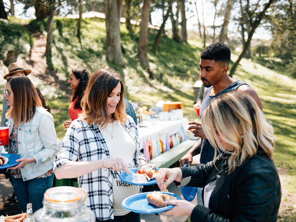 Pregnant woman eating a plate of food at a BBQ