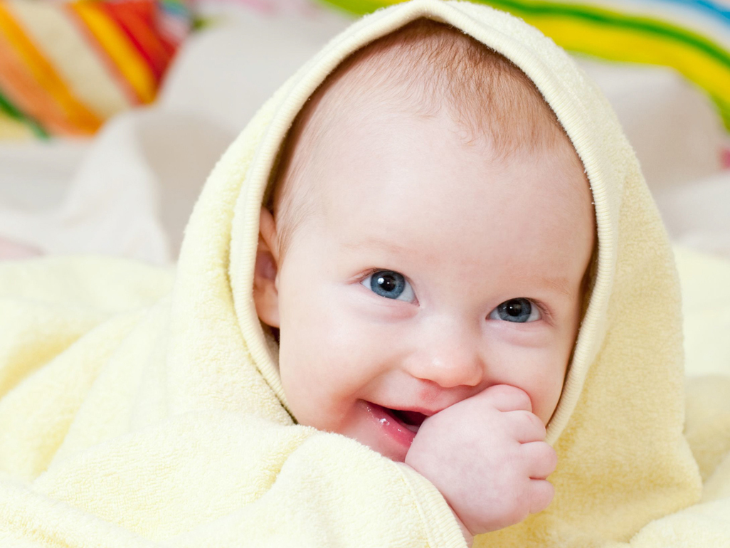 Giggling baby wrapped in a bath towel