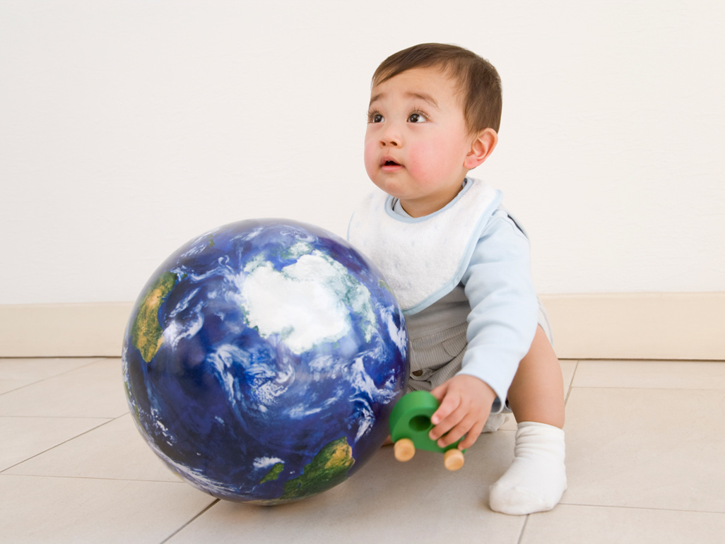 Baby sitting next to globe