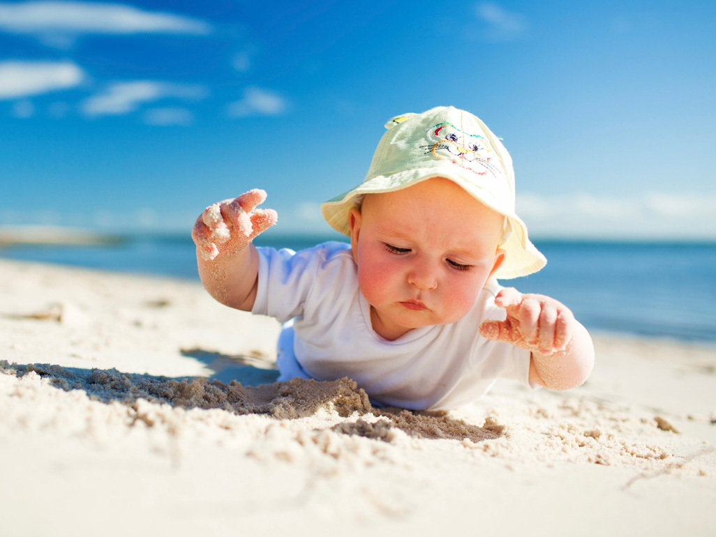 Baby lying on stomach at the beach 