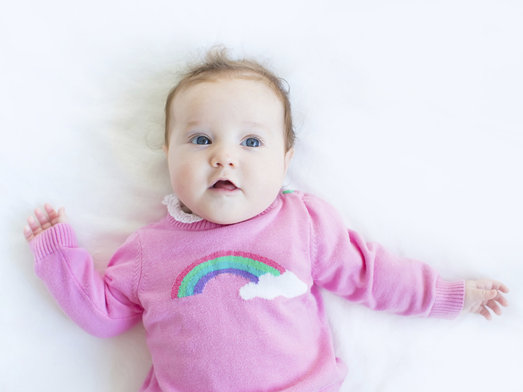 Baby in rainbow jumper