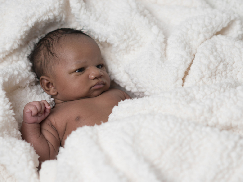 Tiny newborn lying in crib