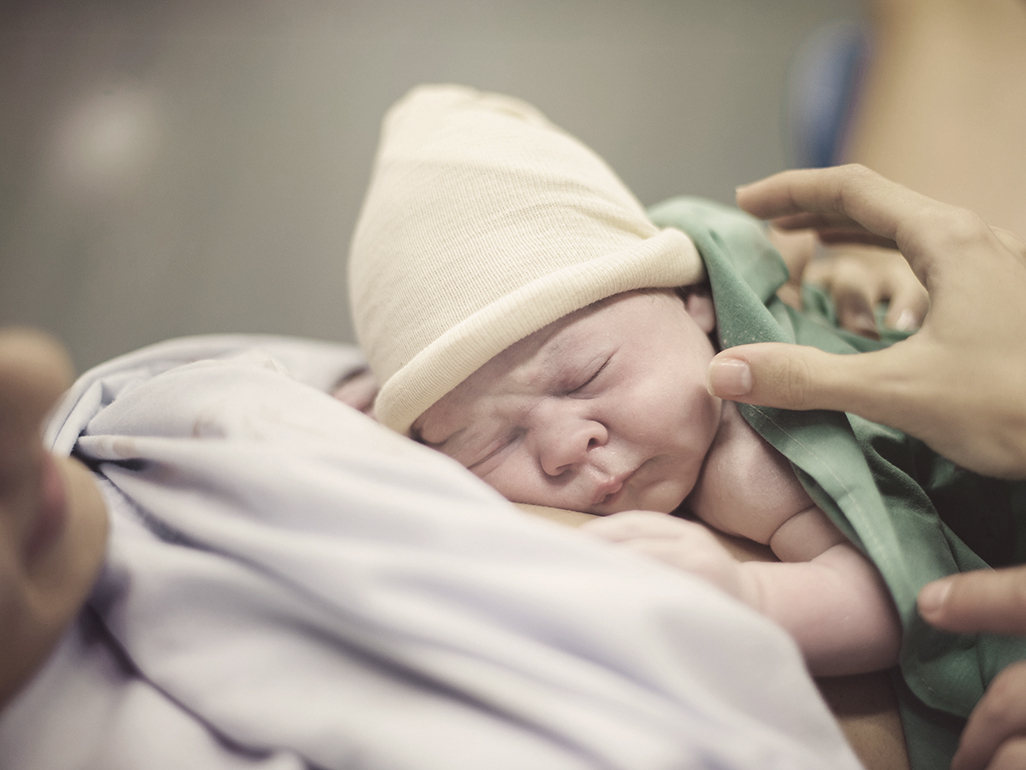 Newborn on mothers chest after birth