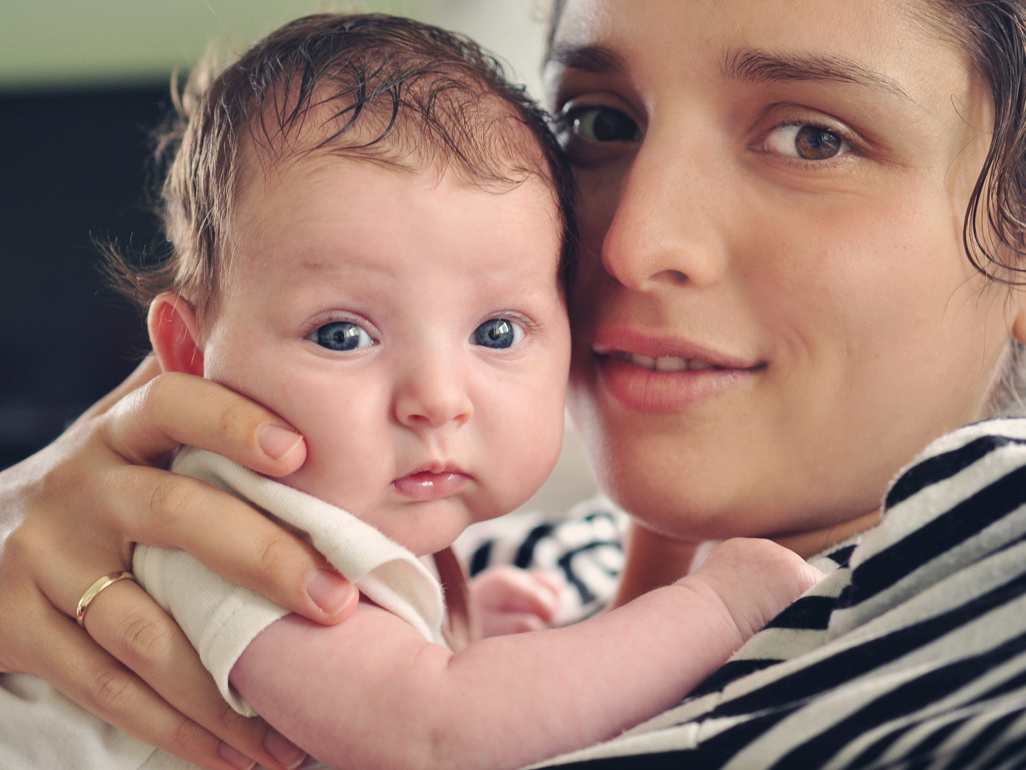 Cute newborn in mothers arms