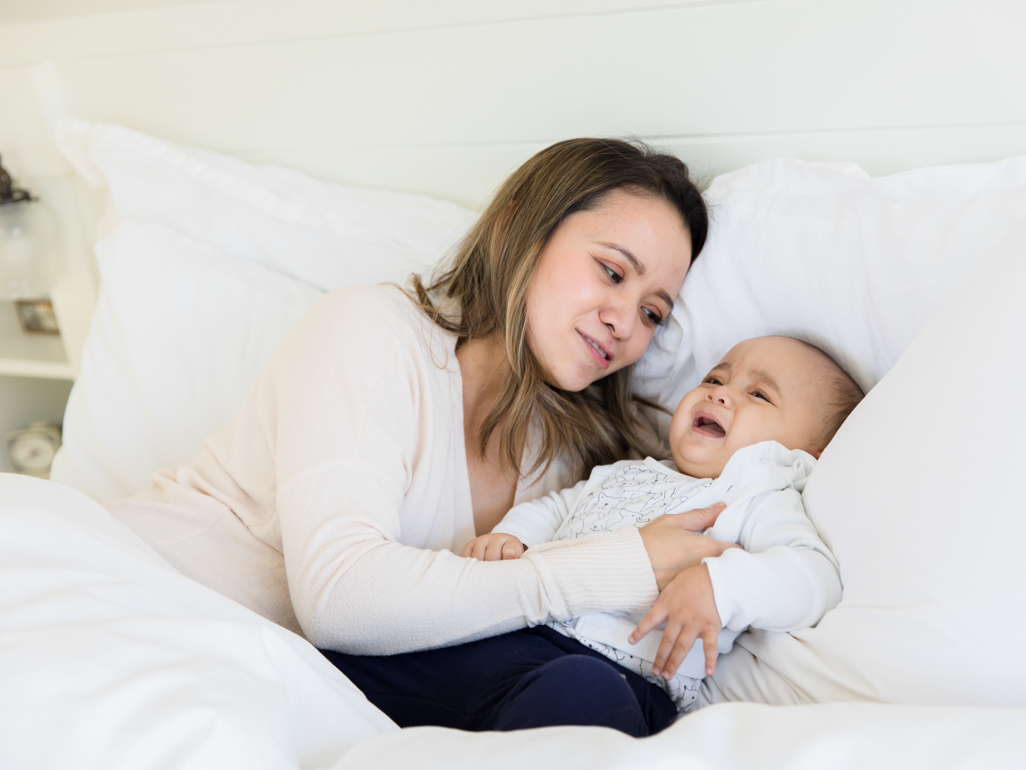 Mum in bed soothing crying baby