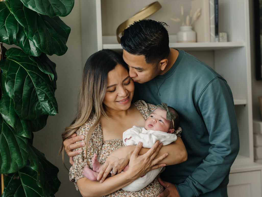Parents smiling and holding their newborn baby
