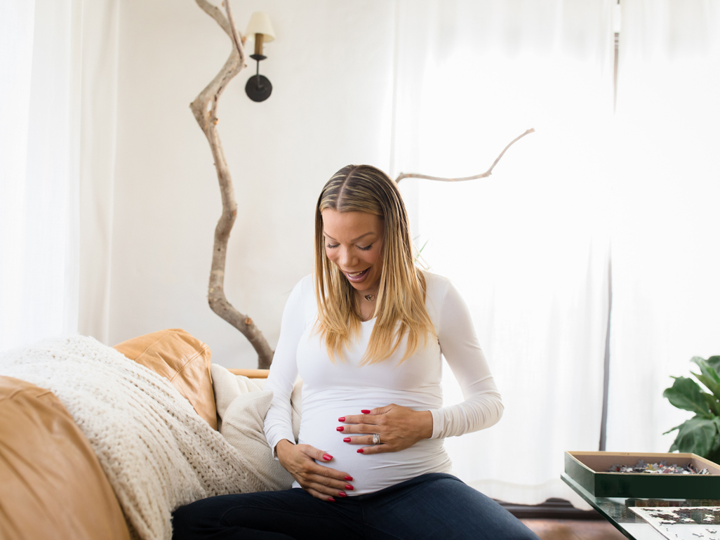 Smiling woman holding her bump