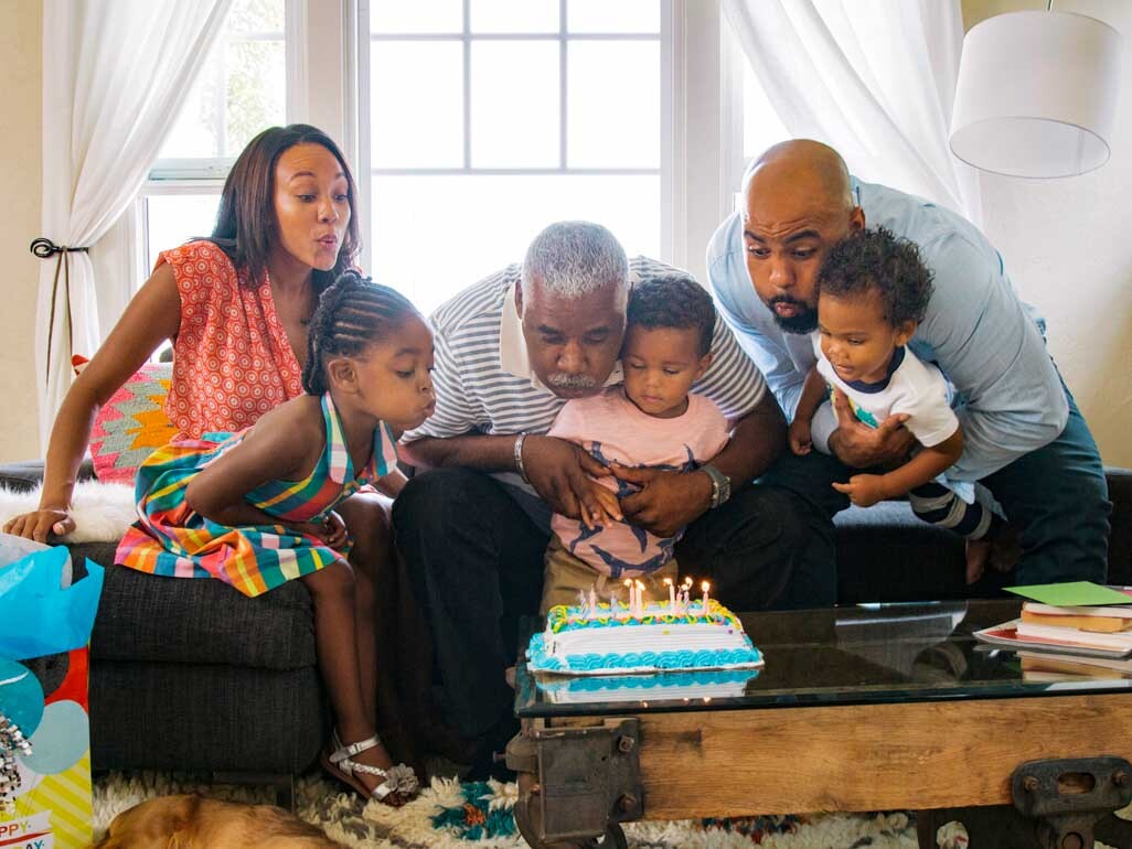 Family blowing out the candles on a cake 