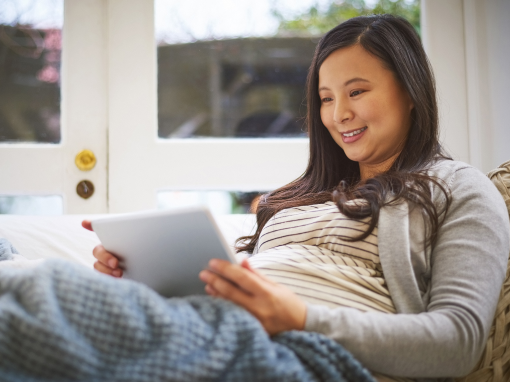 Pregnant woman online shopping on tablet