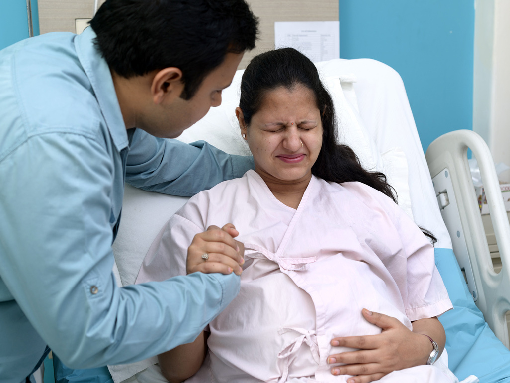 Woman in labour holding her partner's hand