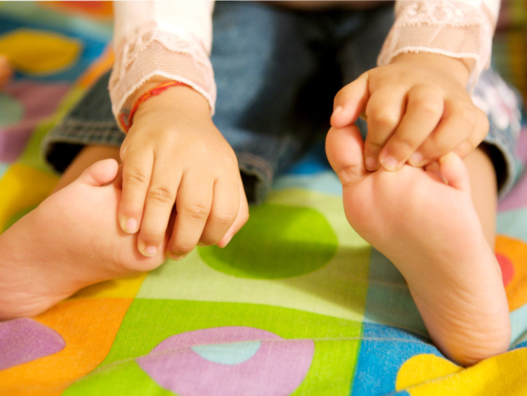 Sitting baby holding onto toes
