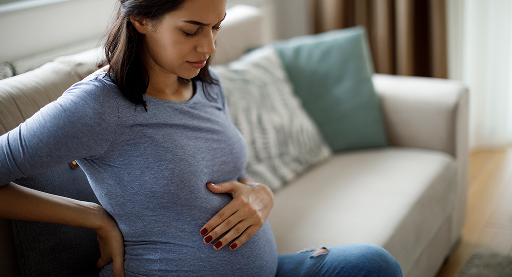 Pregnant woman in pain holding her tummy