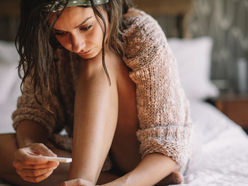 A woman holds a prenancy test waiting for result