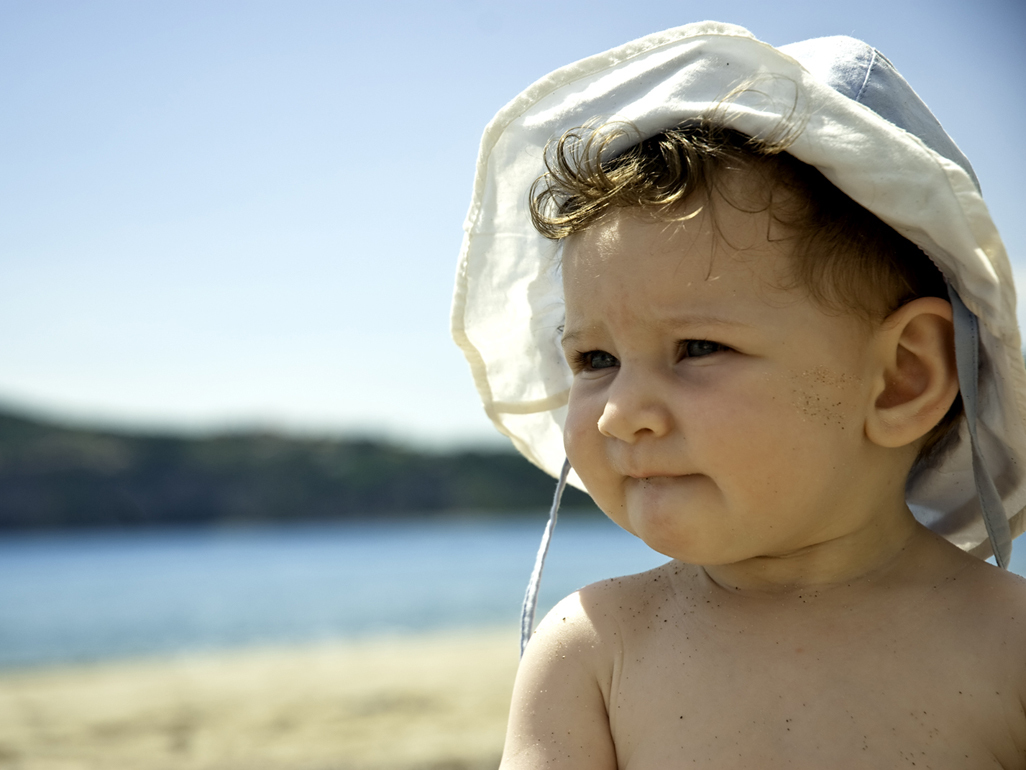 Baby on beach on hot day