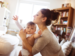 mother dressing her baby
