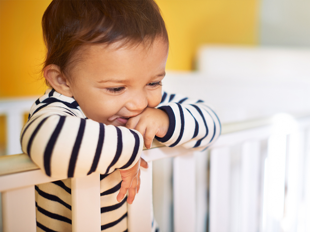 Baby standing up in cot