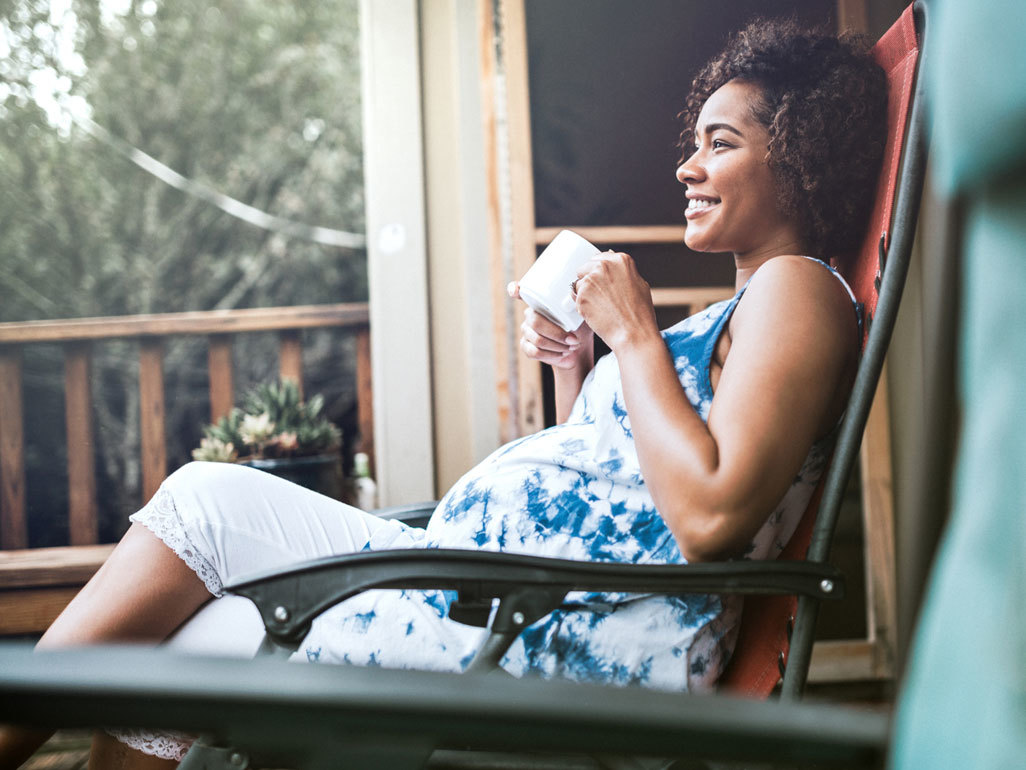 Pregnant woman sitting outside in the summer sun