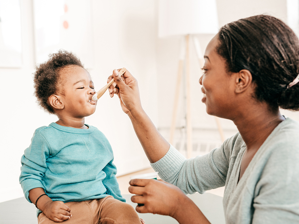 Mother feeding her child food 