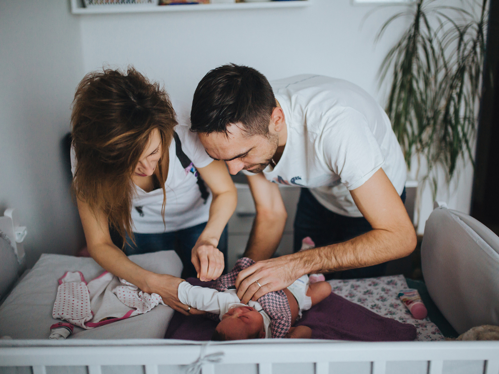 Worried couple changing baby's nappy