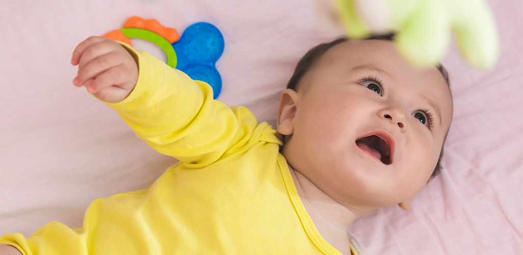 Baby in cot dressed in yellow