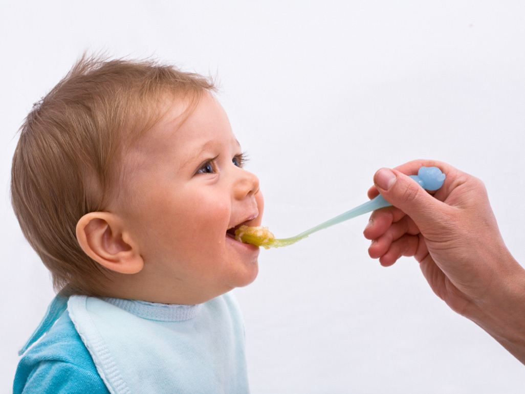 Baby in highchair eating finger foods