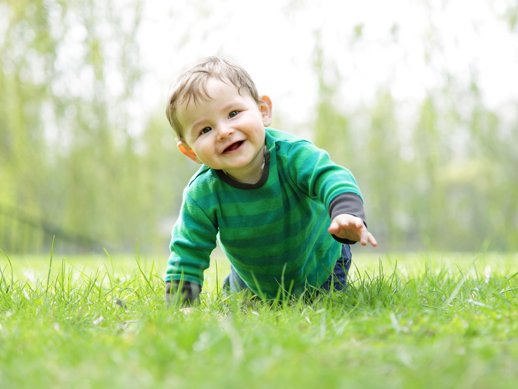 Baby in green t-shirt outdoors