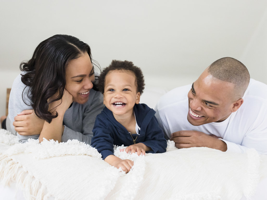 Toddler laughing with mum and dad