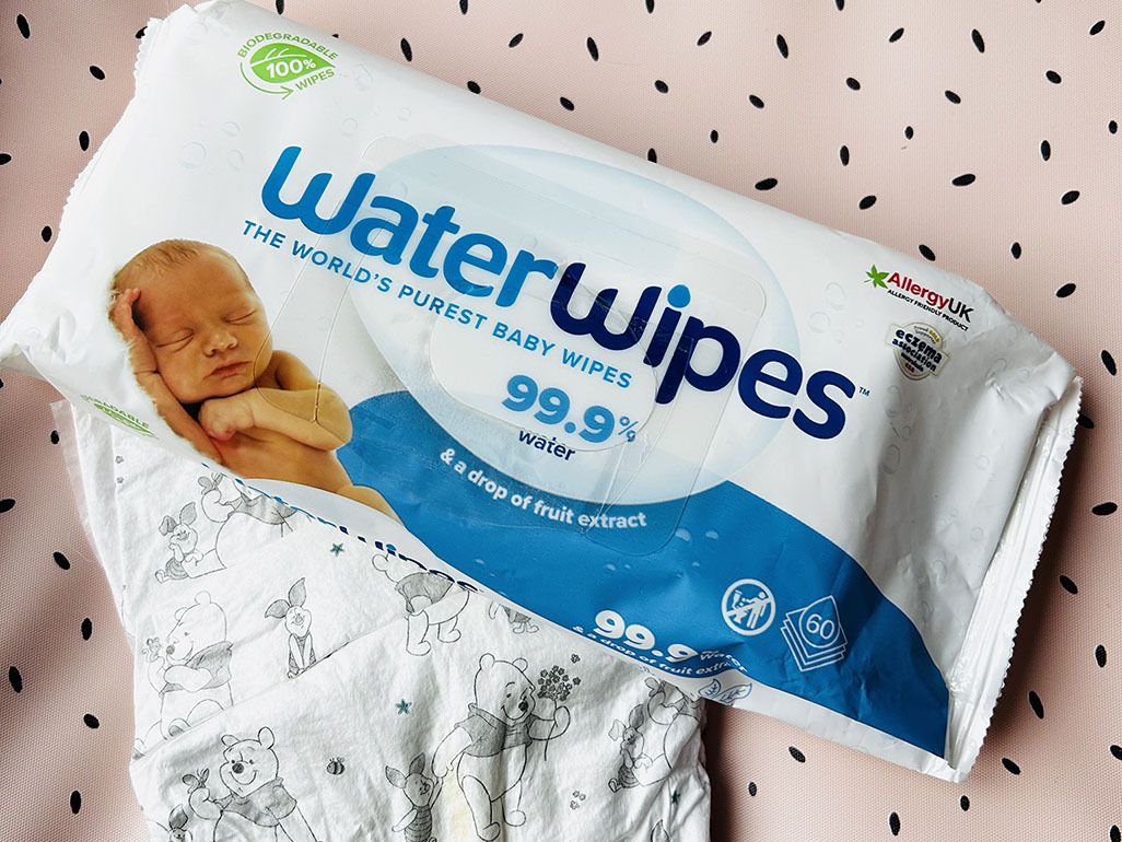 WaterWipes and a nappy on a spotty pink surface