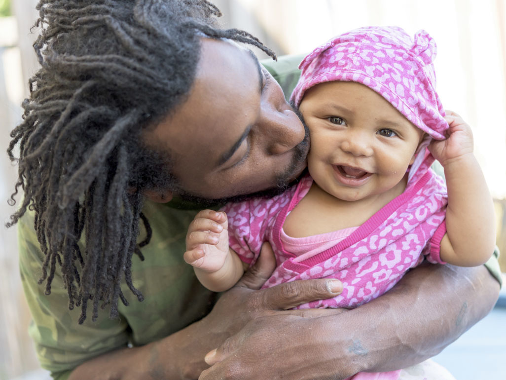 Dad kissing happy baby on the cheek