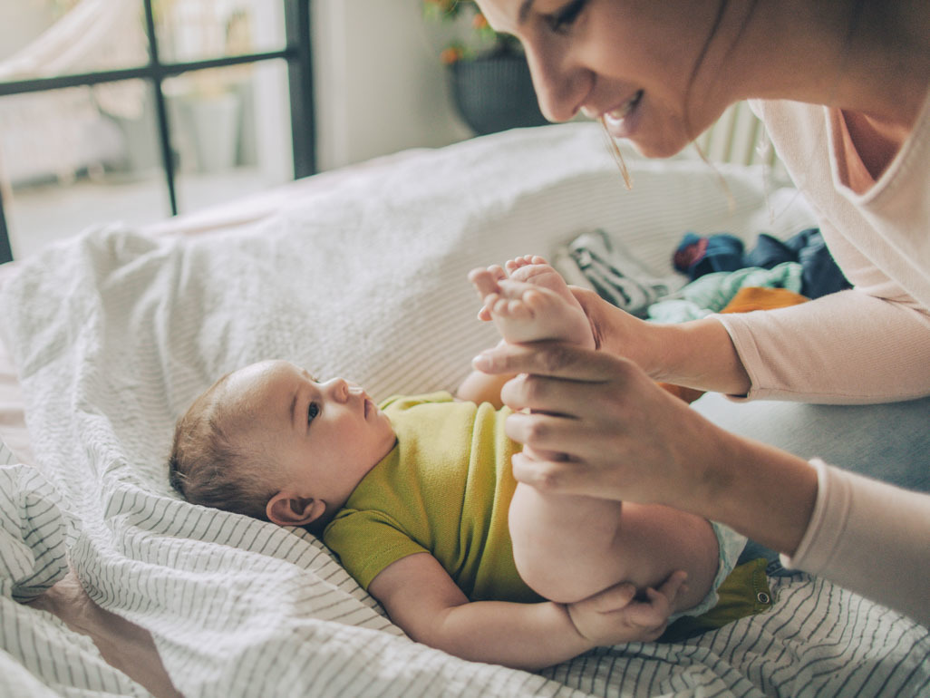 A mum playfully holding her baby's legs