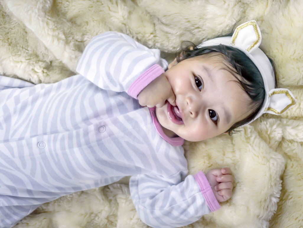 A baby in zebra-striped pajamas