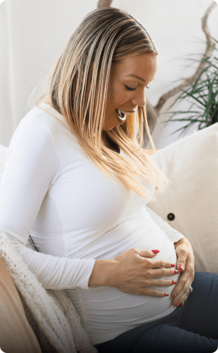woman looking down at her pregnancy bump